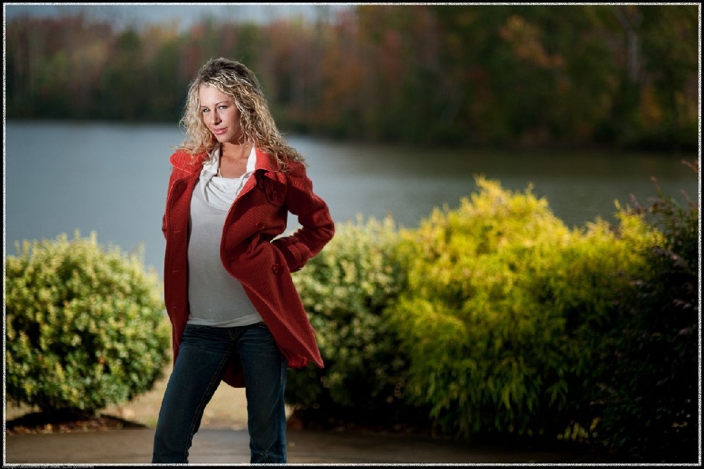 Outdoor portrait using a single off camera flash to create dramatic lighting against a well exposed lakeside autumn background.